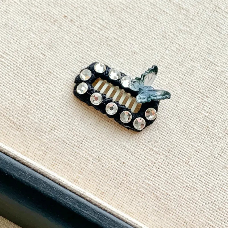 Decorative hair clip with crystals on a textured surface