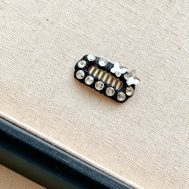 Decorative hair clip with crystals on a beige background