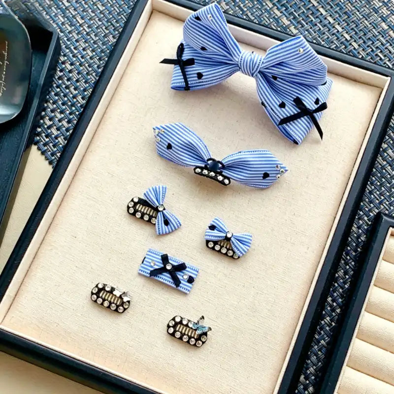 Set of blue and black bow hair accessories on a textured surface
